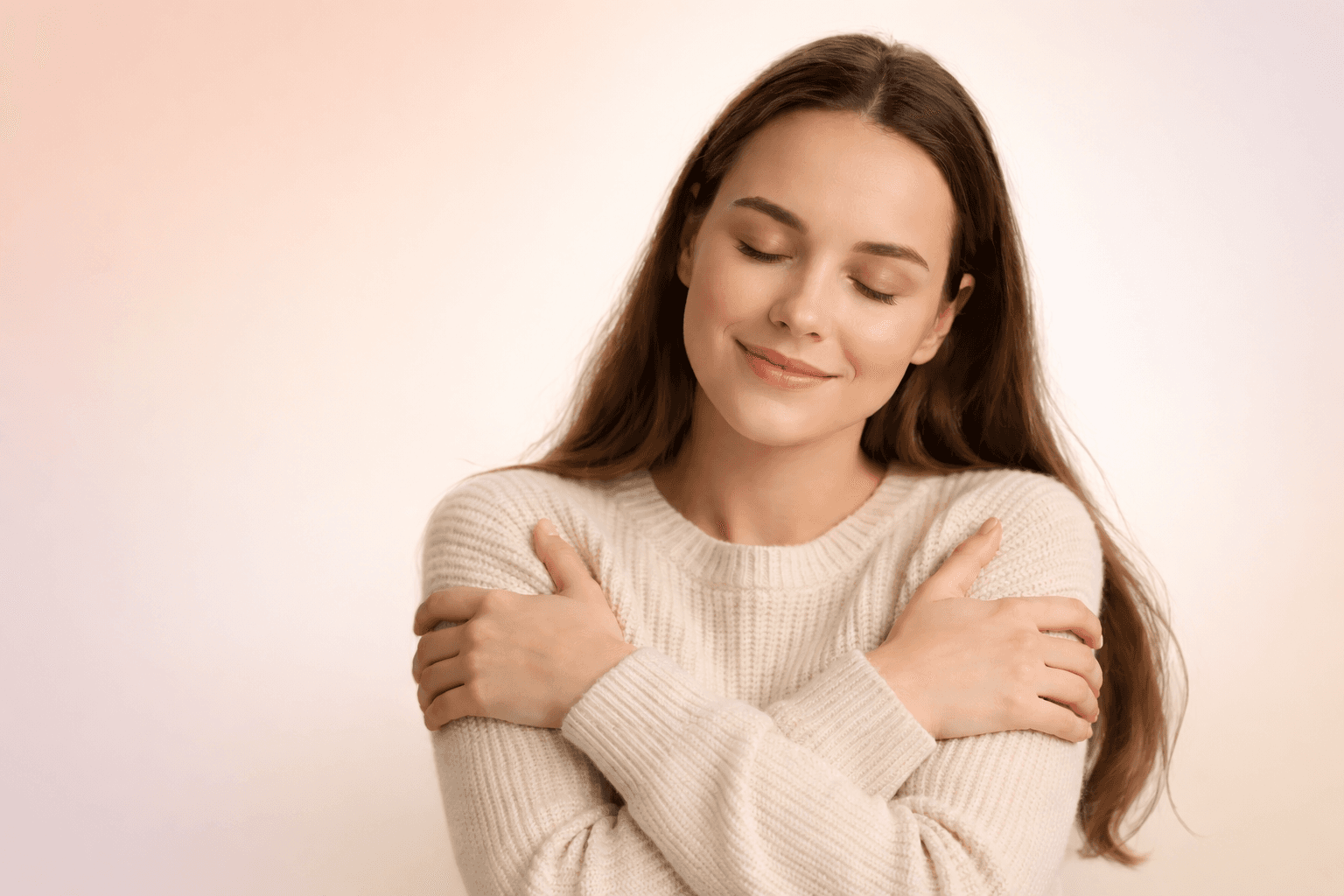 Woman with long brown hair wearing a cream sweater, looking peaceful and content